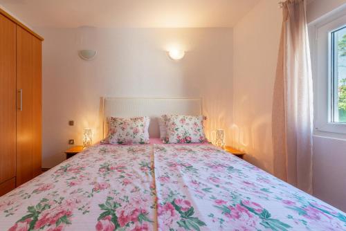 a bedroom with a bed with a floral bedspread at Apartmani Luka in Vir
