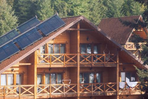 ein großes Holzhaus mit Sonnenkollektoren darauf in der Unterkunft Osonnya Karpaty 4* in Schidnyzja