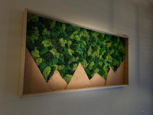 a painting of green plants on a wall at Moje Pieniny Apartament in Szczawnica
