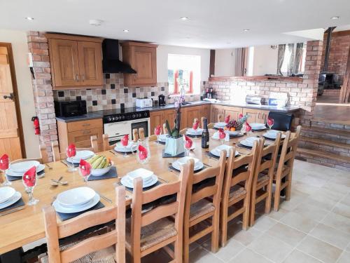 a kitchen with a large wooden table with chairs at Cefnaire Isaf in Newtown