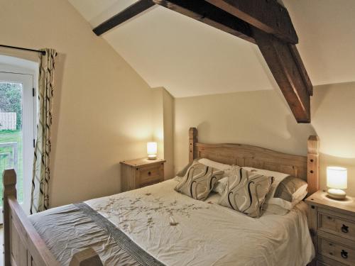 a bedroom with a bed with two night stands and two lamps at The Coach House - Hw7593 in Bettws-yn-Rhôs