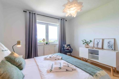ein Schlafzimmer mit einem Bett mit zwei Handtüchern darauf in der Unterkunft Panorama-Apartment 1 I Balkon I WLAN I Stellplatz in Schwarzenberg