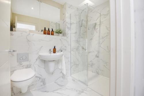 a white bathroom with a toilet and a shower at Apt Three - Private Car Park - 3 shower rooms - by Ocean City Retreats in Plymouth