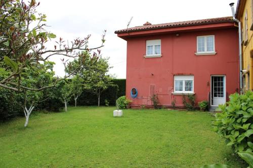 una casa roja con un patio delante en Casa en Castanedo: Casa El Solarón, en Castanedo