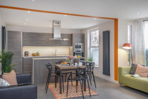 a kitchen and living room with a table and chairs at Apt Three - Private Car Park - 3 shower rooms - by Ocean City Retreats in Plymouth