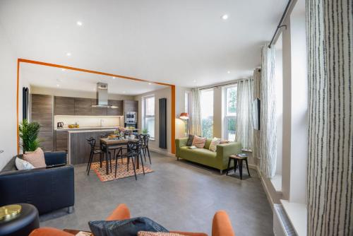 a living room and kitchen with a couch and a table at Apt Three - Private Car Park - 3 shower rooms - by Ocean City Retreats in Plymouth