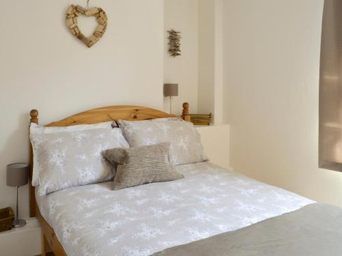 een bed met witte lakens en kussens erop bij St Martins Square Apartment 2 in Scarborough