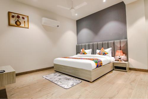 ein Schlafzimmer mit einem Kingsize-Bett in einem Zimmer in der Unterkunft FabHotel Prime K9 Grand in Ludhiana