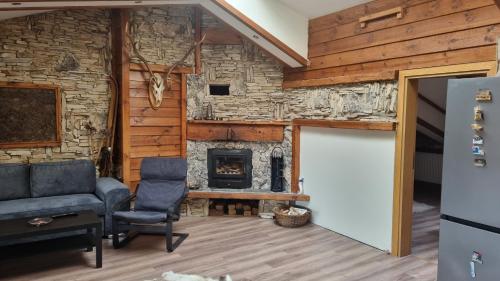 a living room with a stone fireplace and a door at Pirin Studios in Bansko
