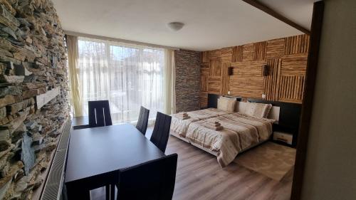 a bedroom with a bed and a table with chairs at Pirin Studios in Bansko