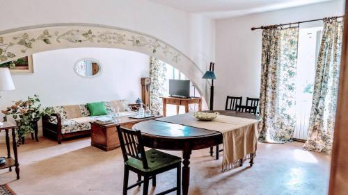 uma sala de estar com uma mesa e um sofá em Exclusive pool - wondrous views - biological Gardens - pool house - 11 guests em Marzolini