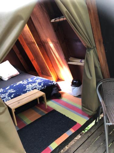 1 dormitorio en una tienda de campaña con 1 cama y 1 silla en Glamping Laguna Sagrada, en Bobadilla