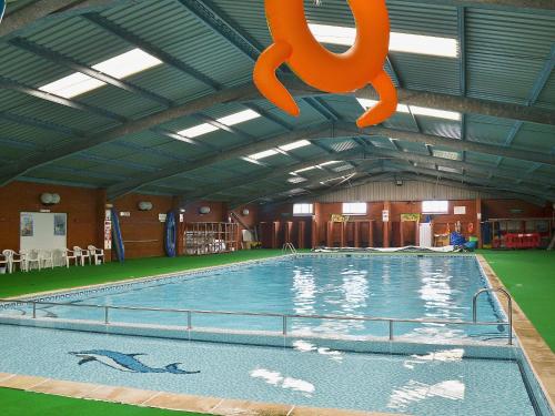 una gran piscina con un símbolo naranja colgando del techo en Sandy Den, en Scratby