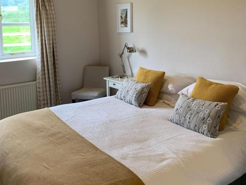 a bedroom with a bed with two pillows and a desk at Cow Shed in Farden