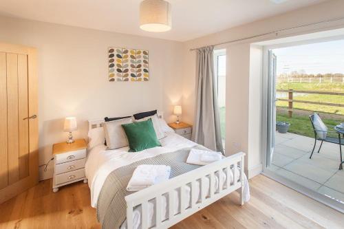 a bedroom with a bed and a sliding glass door at The Dairy Parlour in Cricklade