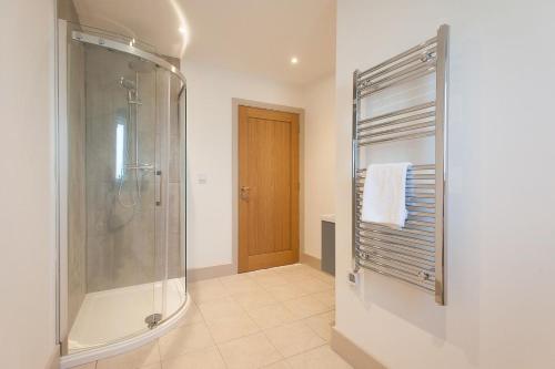 a bathroom with a shower and a glass shower stall at The Dairy Parlour in Cricklade