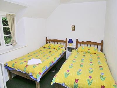 WithycombeにあるTacker Street Cottageのベッド2台が隣同士に設置された部屋です。