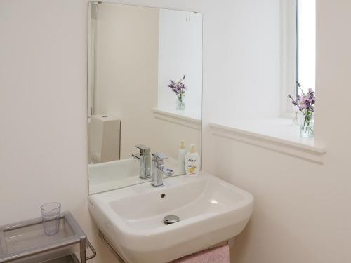 a white bathroom with a sink and a mirror at Foundry Bank in Bonar Bridge