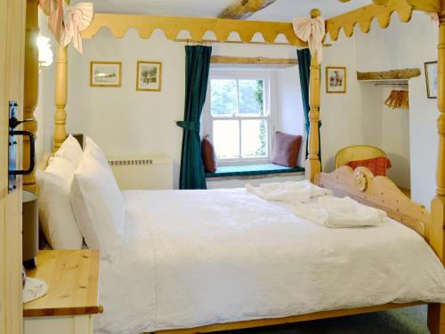 a bedroom with a large bed and a window at Redmayne Cottage in Orton