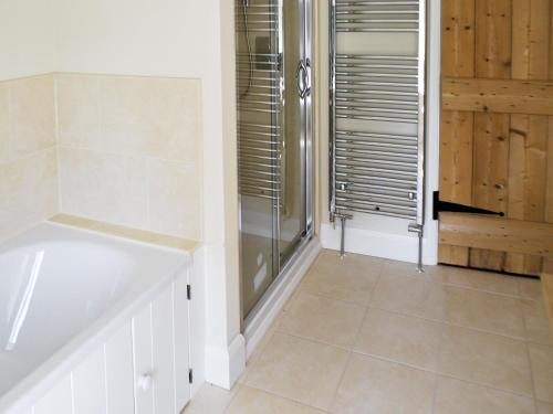 a bathroom with a shower and a tub at Bank Cottage in Grindleford Bridge