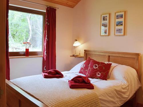 a bedroom with a bed with red towels on it at Rowanburn Lodge in Ellonby