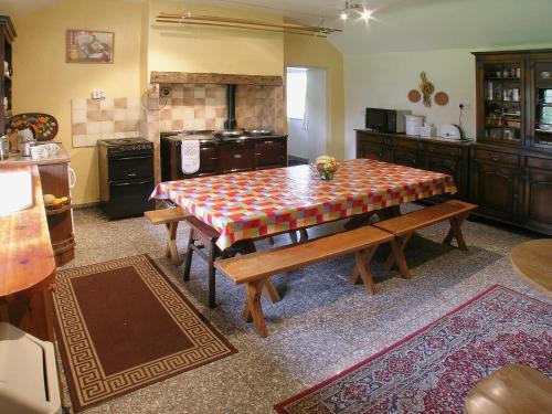 a kitchen with a table and benches in it at Crook Farm in Torver