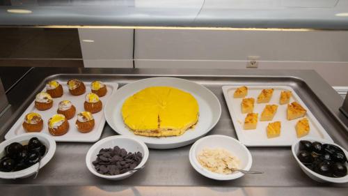 a table with a cake and several bowls of desserts at Karras Hotel in Laganas