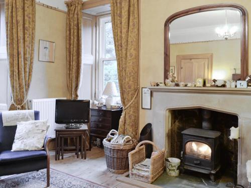 a living room with a fireplace and a mirror at Ewes Schoolhouse in Bentpath