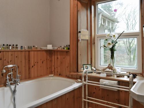 a bath tub in a bathroom with a window at Ewes Schoolhouse in Bentpath