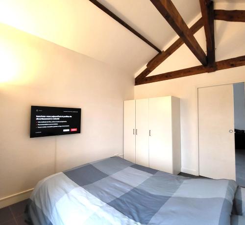 - une chambre avec un lit et une télévision murale dans l'établissement Residence du Parc des Grottes - N 3, à Juvisy-sur-Orge