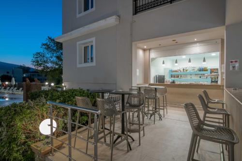 a bar with chairs and tables on a patio at Karras Hotel in Laganas