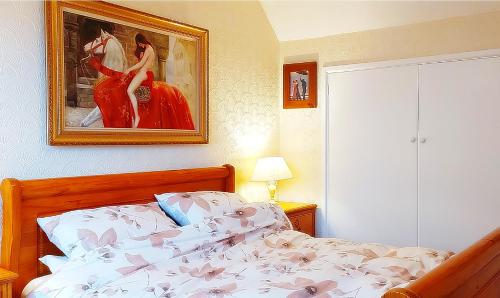 a bedroom with a bed and a painting of a woman at Sunshine Cottage - You'll adore this Fabulous Holiday Gem Just mins from the Beach for the Perfect Seaside Getaway with FREE Parking & Fast FREE WiFi! 3 Bed & Sleeps 1 to 5 Guests in Chapel Saint Leonards