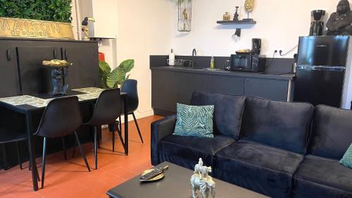 a living room with a couch and a table at Le Troglo'Gîte, 500m à pied du Zoo de Beauval in Seigy