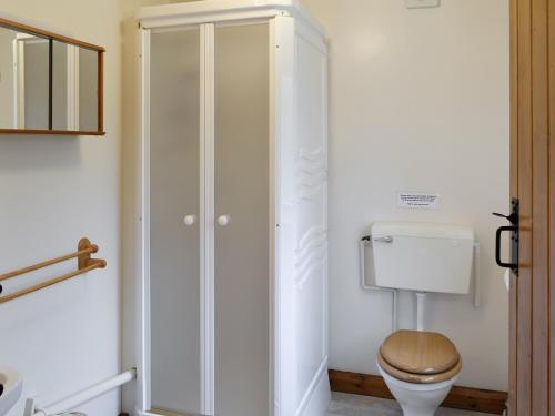 uma casa de banho com um WC e um armário branco em Rose Cottage - W41462 em Sturminster Newton