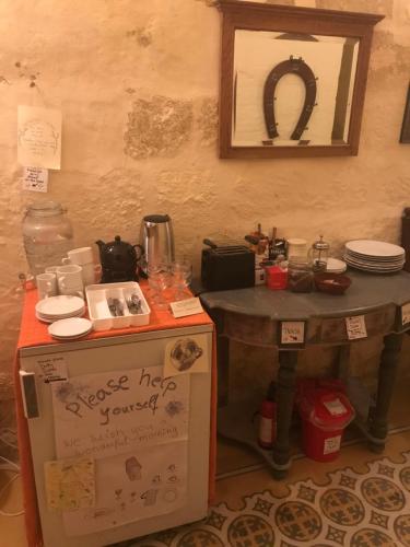 a table in a room with a counter with plates at Peaceful Farmhouse stay with cozy Yard in Għarb