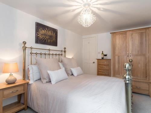 a bedroom with a bed and a chandelier at One Beckside Cottage in Staithes