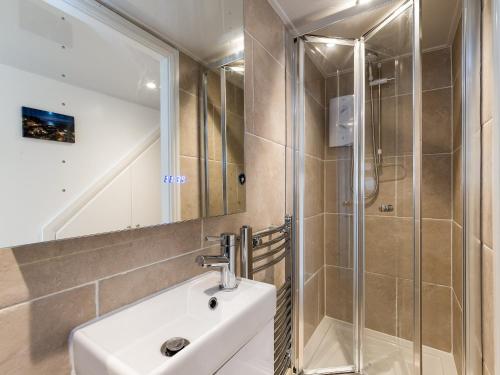 a bathroom with a sink and a shower at One Beckside Cottage in Staithes