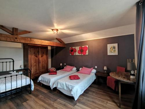 - une chambre avec 2 lits et des oreillers rouges dans l'établissement Aux Acacias, à Braye-sous-Faye