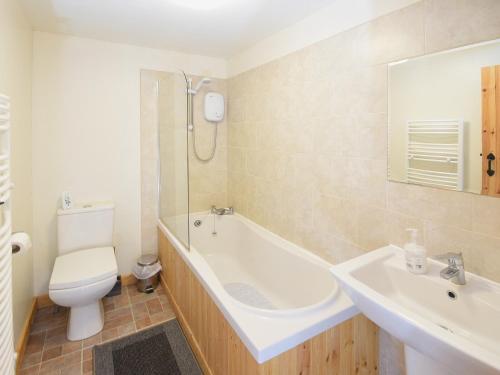 a bathroom with a tub and a toilet and a sink at Bramble Cottage - 27978 in Whalley