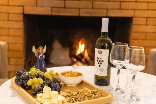 a bottle of wine and a plate of food and wine glasses at Hotel 1700 in Bakuriani