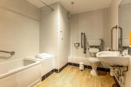 a bathroom with a sink and a toilet and a bath tub at Days Inn Peterborough in Peterborough