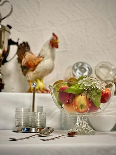 a bowl of fruit and a chicken on a table at Hotel Brunnenhof in Bad Nauheim