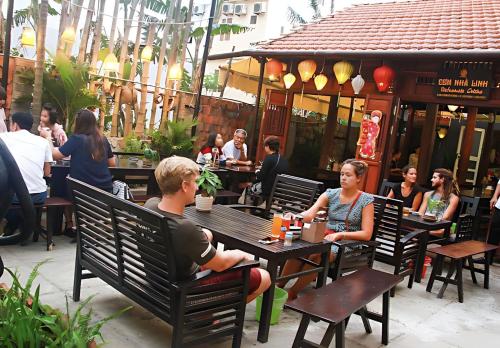 a group of people sitting at tables in a restaurant at Phuc Thanh Luxury Hotel by THG in Da Nang