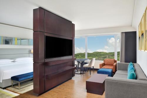 a living room with a large entertainment center at Courtyard by Marriott Navi Mumbai in Navi Mumbai