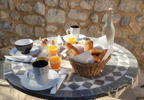 una mesa con una cesta de pan y una botella de leche en Chambre d'hôte La Pierre, en Conne-de-Labarde
