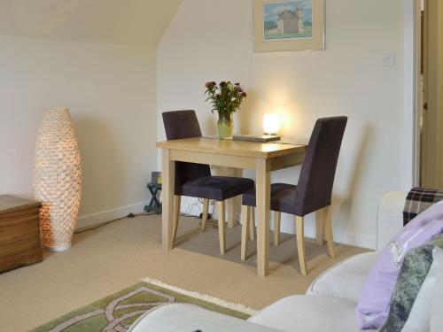 a dining room table with two chairs and a candle on it at Kerloch View in Banchory