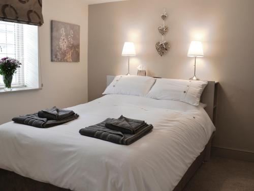 a bedroom with two towels on a white bed at Back O The Beck in Skipton