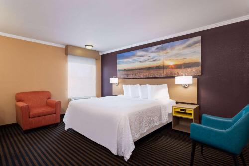 um quarto de hotel com uma cama e duas cadeiras em Days Inn by Wyndham Anderson IN em Anderson