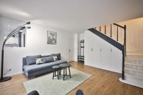 een woonkamer met een bank en een trap bij 2.Luxueux Duplex 6/8pers/Full Equipped/République in Parijs