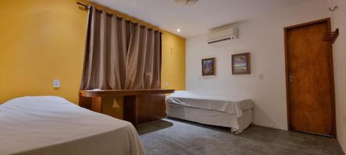 a hospital room with two beds and a window at Aldeias Guajiru Apart in Trairi